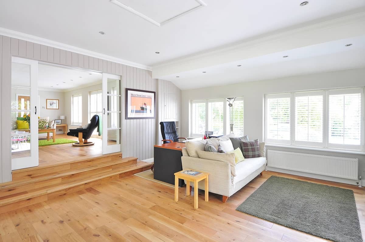 Light oak engineered hardwood planks in a bright living room with a step-up sunroom